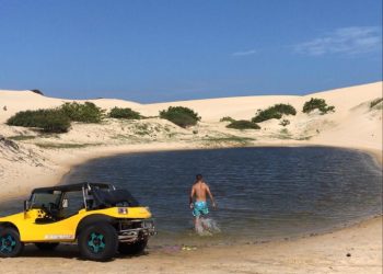 Buggy e pessoa num lago entre as dunas